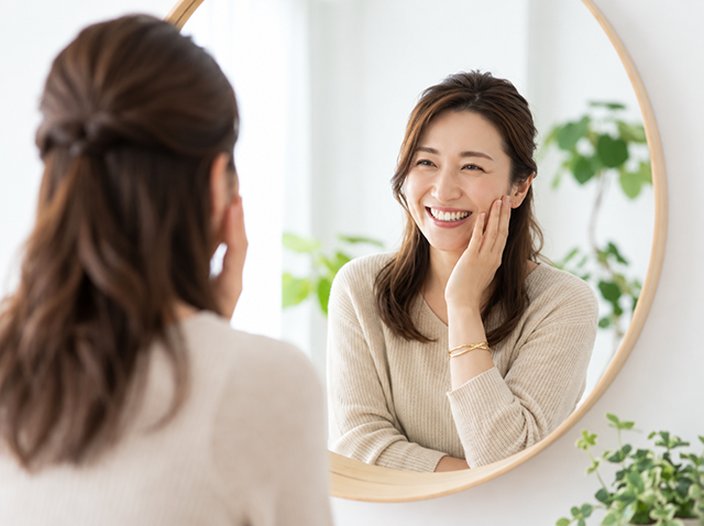 鏡の前で身支度をする女性のイメージ